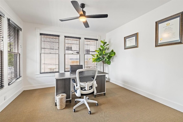 carpeted office space featuring ceiling fan and a healthy amount of sunlight