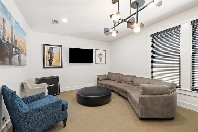 carpeted living room featuring an inviting chandelier