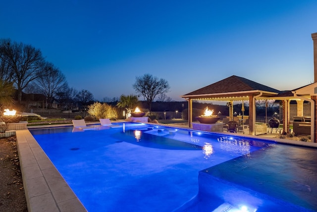 pool at dusk with a gazebo and a patio area