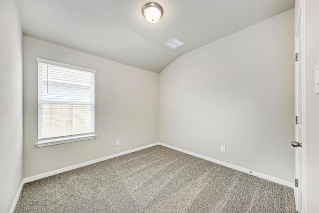 carpeted empty room with lofted ceiling