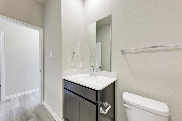 bathroom featuring vanity, hardwood / wood-style floors, and toilet