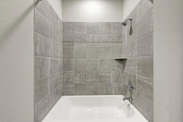 bathroom featuring tiled shower / bath