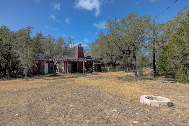 465 Hannah Dr, Dripping Springs, TX 78620 - rear view of house featuring a fire pit and a chimney