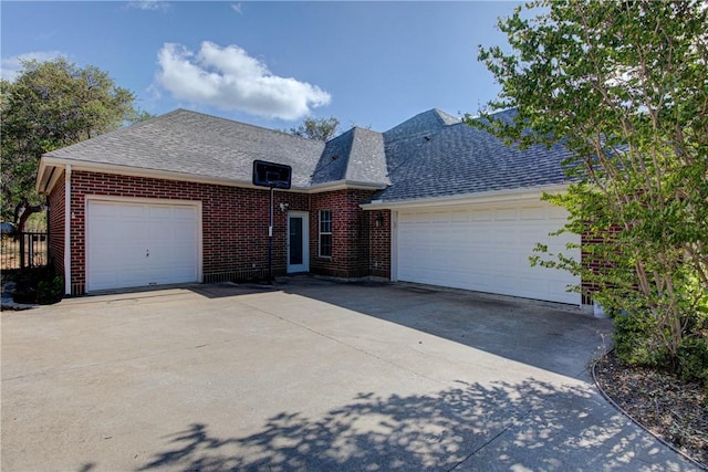 465 Hannah Dr, Dripping Springs, TX 78620 - view of front of home featuring roof with shingles, a garage, driveway, and brick siding