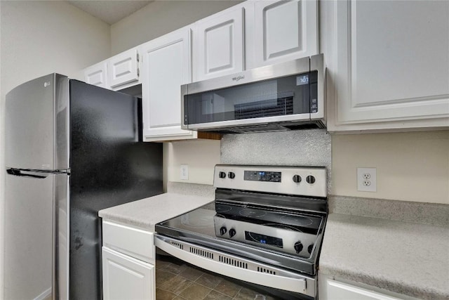 kitchen featuring stainless steel appliances, white cabinets, light countertops, and backsplash