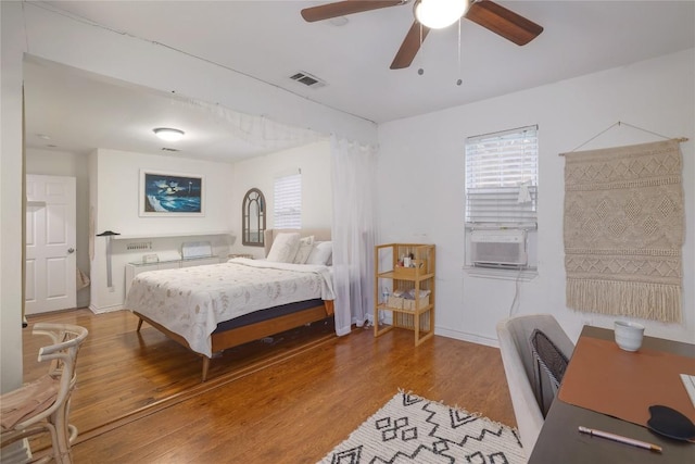 1406 Webberville Rd, Austin, TX 78721 - bedroom featuring wood finished floors, cooling unit, and a ceiling fan