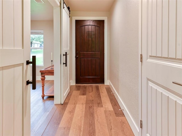 entryway featuring light hardwood / wood-style floors and a barn door