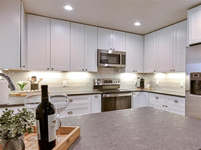 kitchen with white cabinetry, appliances with stainless steel finishes, and decorative backsplash