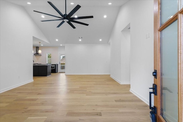 unfurnished living room with high vaulted ceiling, light hardwood / wood-style floors, and ceiling fan