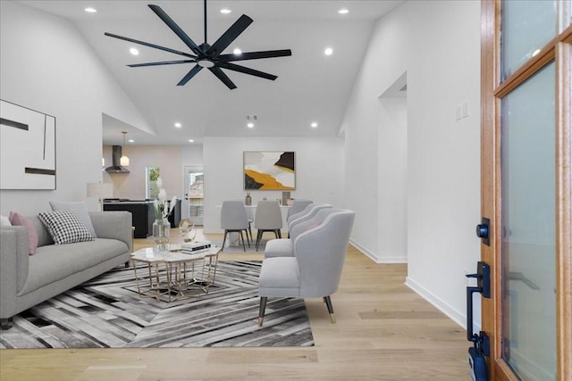 living room featuring high vaulted ceiling and light wood-type flooring