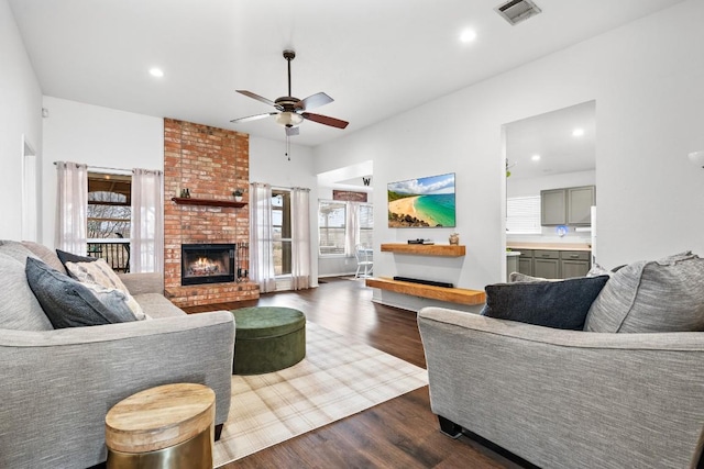 living room with a fireplace, dark hardwood / wood-style floors, and ceiling fan