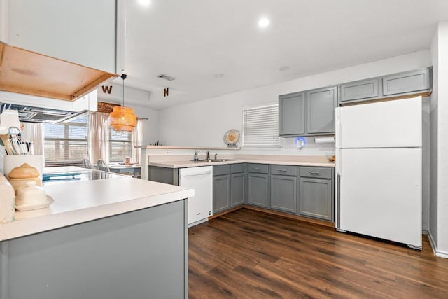 kitchen with hanging light fixtures, gray cabinets, white appliances, and kitchen peninsula