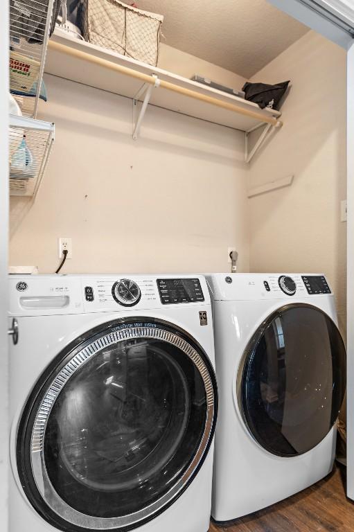 laundry area featuring dark hardwood / wood-style floors and washer and dryer