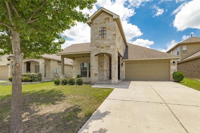 view of front facade with a garage, a shingled roof, stone siding, concrete driveway, and a front yard