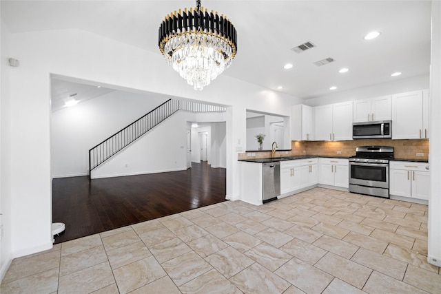 kitchen featuring white cabinetry, appliances with stainless steel finishes, and tasteful backsplash