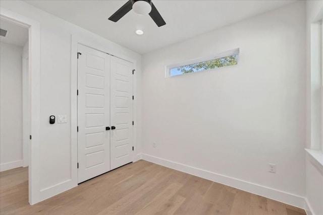 unfurnished bedroom featuring ceiling fan, light wood-type flooring, and a closet