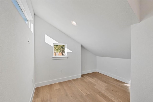 additional living space with lofted ceiling and light hardwood / wood-style flooring