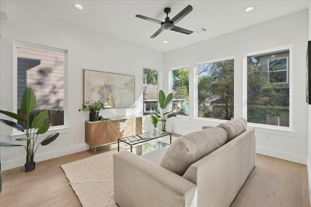 living room featuring ceiling fan and light hardwood / wood-style floors