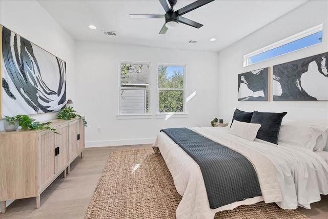 bedroom featuring ceiling fan, light hardwood / wood-style floors, and multiple windows