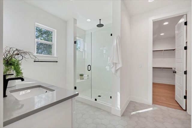 bathroom featuring an enclosed shower and sink