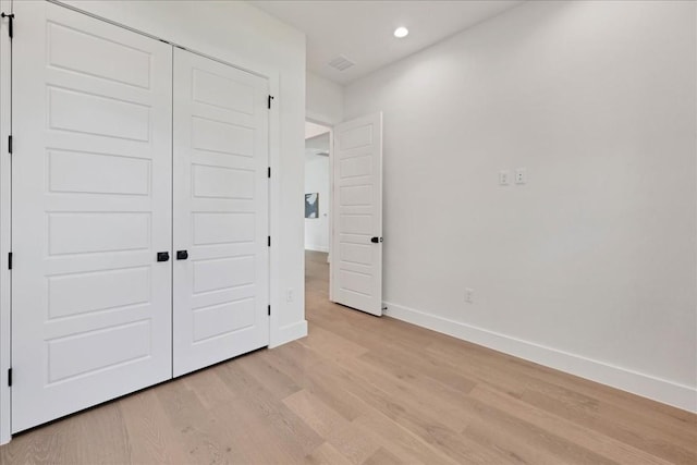 unfurnished bedroom featuring light hardwood / wood-style floors and a closet