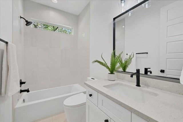 full bathroom featuring tiled shower / bath, vanity, and toilet