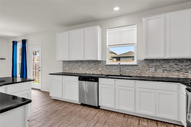 kitchen with stainless steel dishwasher, sink, white cabinetry, and light hardwood / wood-style floors