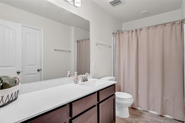 bathroom with hardwood / wood-style flooring, toilet, and vanity