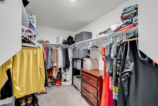 spacious closet featuring light colored carpet