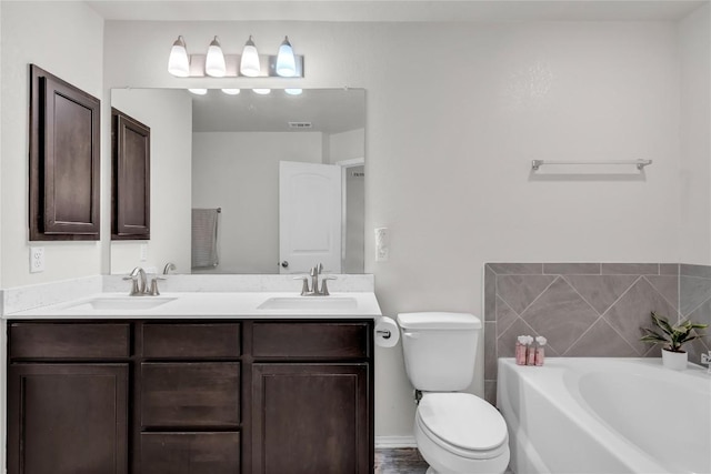 bathroom with toilet, vanity, and a bathing tub