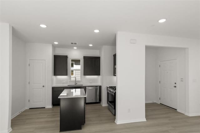 168 Bosque Dr, San Marcos, TX 78666 - kitchen featuring stainless steel dishwasher, gas range, a sink, a center island, and light wood-type flooring