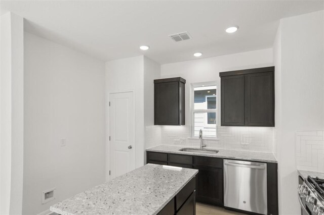 168 Bosque Dr, San Marcos, TX 78666 - kitchen with stainless steel appliances, a sink, decorative backsplash, light stone counters, and recessed lighting