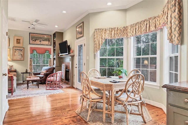 2716 Hillview Green Ln, Austin, TX 78703 - dining space featuring crown molding, ceiling fan, light wood-style floors, a fireplace, and baseboards