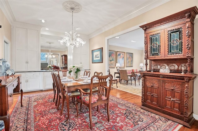 dining room featuring light hardwood / wood-style floors, a chandelier, and crown molding