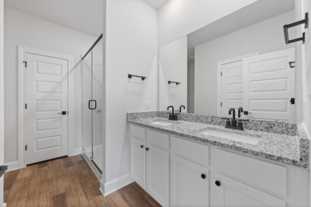 bathroom with hardwood / wood-style flooring, walk in shower, and vanity