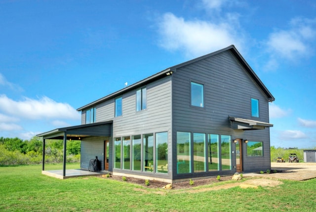 rear view of house with a yard and a patio