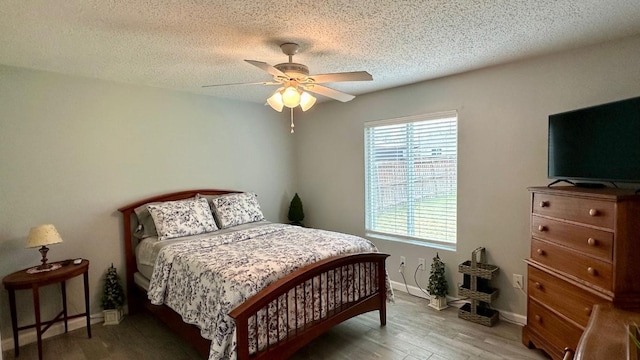 bedroom featuring hardwood / wood-style flooring, ceiling fan, and a textured ceiling