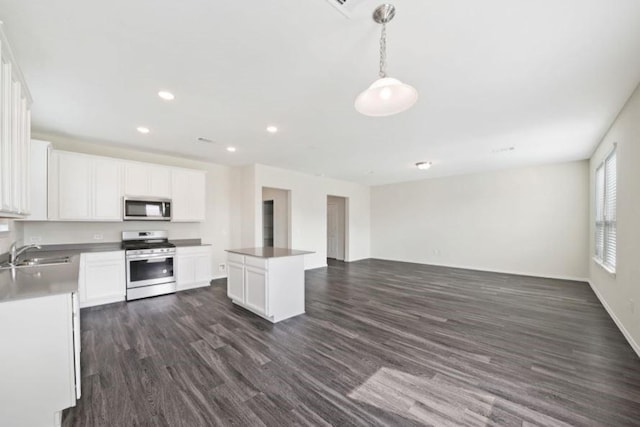 kitchen featuring white cabinetry, sink, stainless steel appliances, and decorative light fixtures