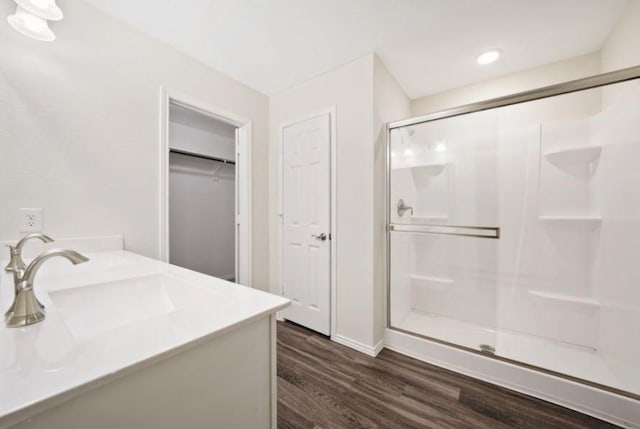 bathroom with hardwood / wood-style flooring, vanity, and walk in shower