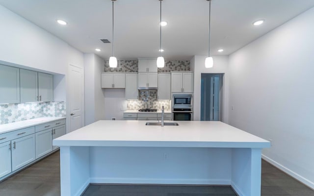 kitchen featuring hanging light fixtures, an island with sink, appliances with stainless steel finishes, and sink