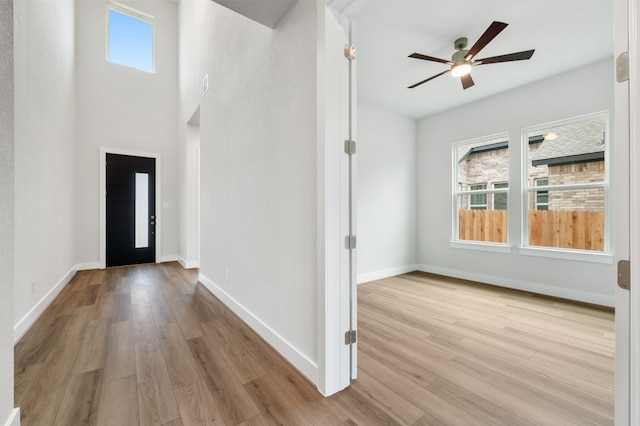 foyer entrance featuring baseboards, ceiling fan, and wood finished floors