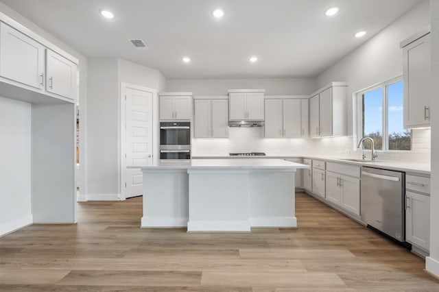 kitchen with recessed lighting, appliances with stainless steel finishes, a sink, and a center island