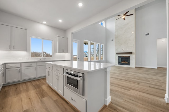 kitchen featuring oven, ceiling fan, recessed lighting, light countertops, and backsplash