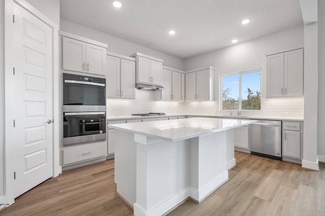 kitchen with a sink, a center island, tasteful backsplash, and stainless steel appliances