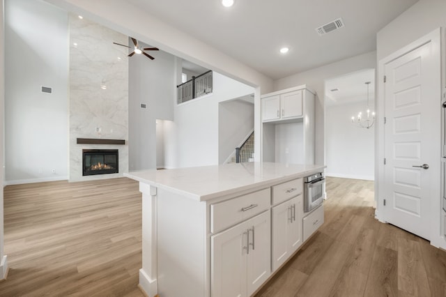 kitchen with white cabinets, oven, baseboards, and visible vents