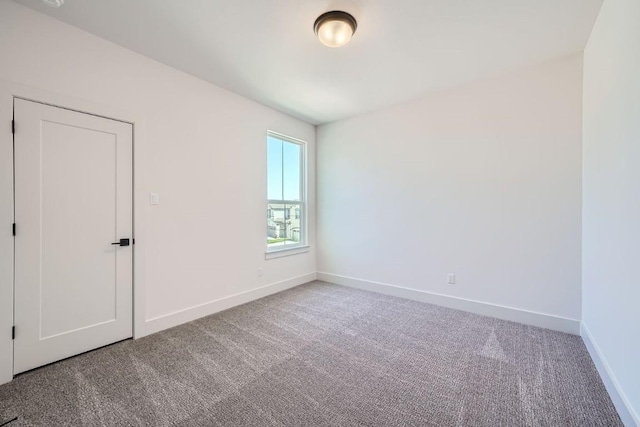 carpeted empty room with baseboards