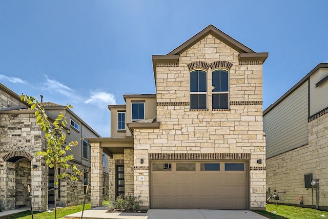 french country home featuring a garage, stone siding, and driveway