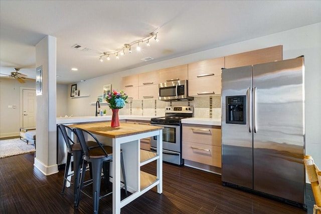 kitchen featuring wooden counters, stainless steel appliances, dark hardwood / wood-style flooring, and light brown cabinetry