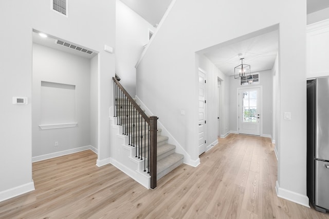 entrance foyer featuring light hardwood / wood-style floors and an inviting chandelier