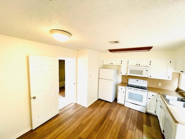 kitchen featuring white appliances, sink, dark hardwood / wood-style flooring, and white cabinets